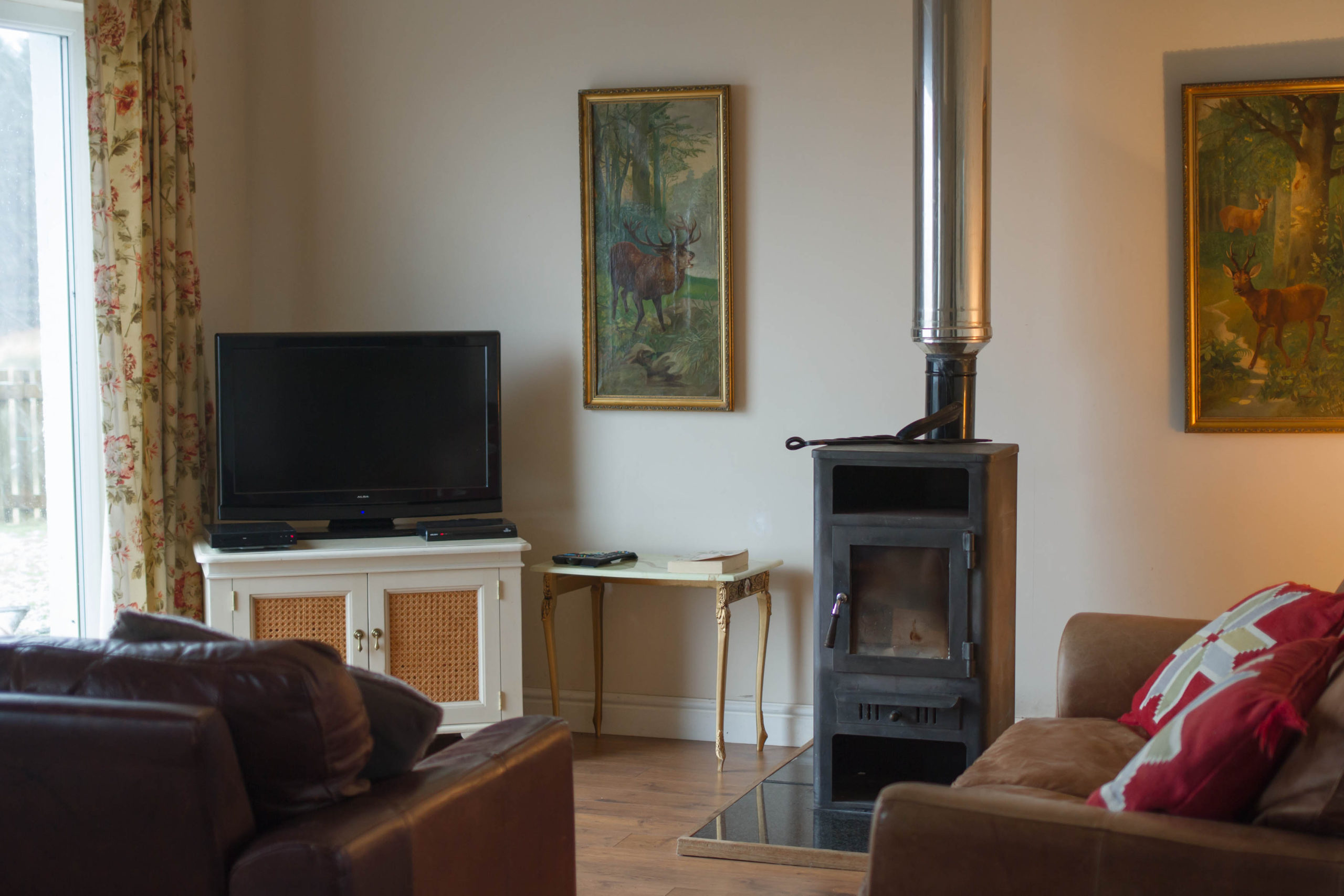 Photo of Poppies Cottage, Mull. Showing a wood burner and sofas