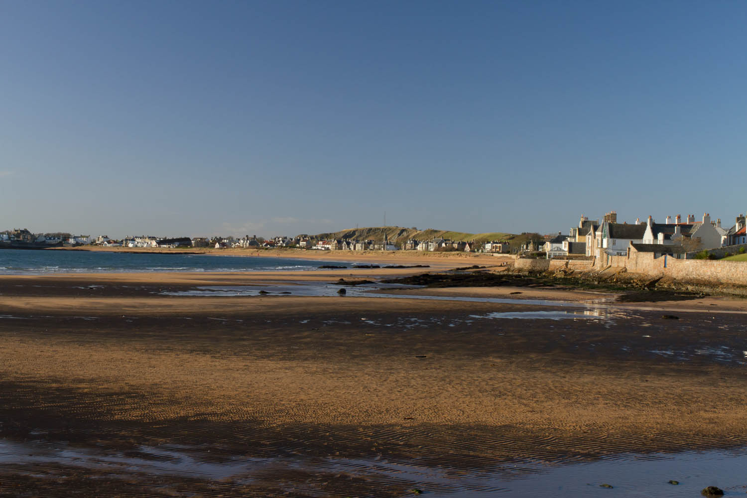 Elie, East Neuk, Fife, Scotland. Large beach. The tide is out but the sand is still damp. Houses overlooking the beach 