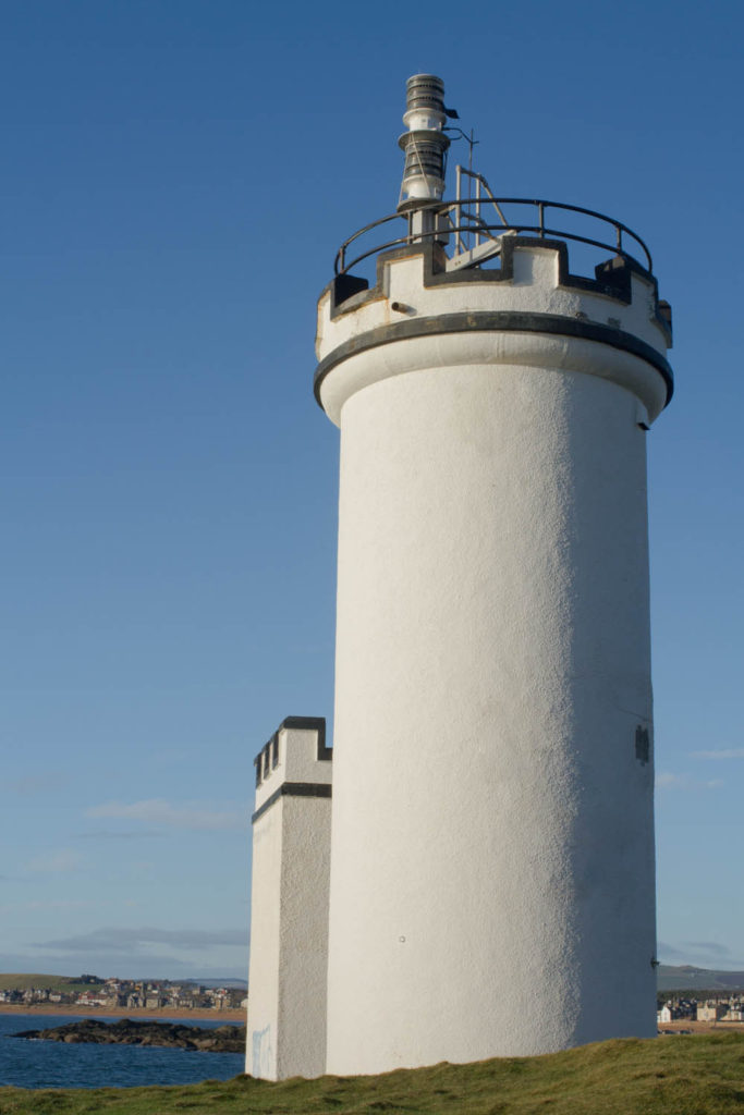 Elie Ness Lighthouse, Fife, Scotland. A white lighthouse tower with small turrets. 