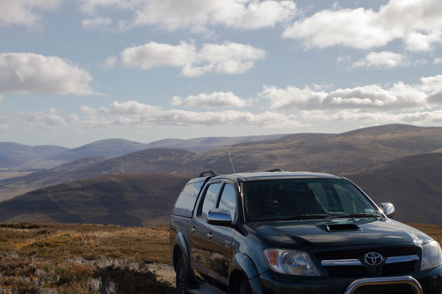 Glenesk Wildlife tour, 4x4 off road vehicle up on the hillside. Large clouds overhead