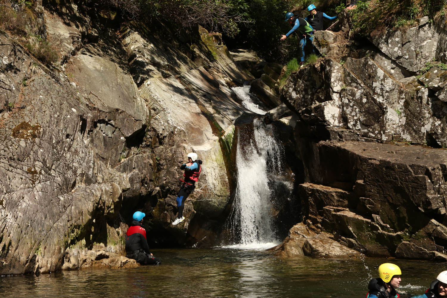 Cayoning in Perthshire. Man jumping off a rock into a large pool 