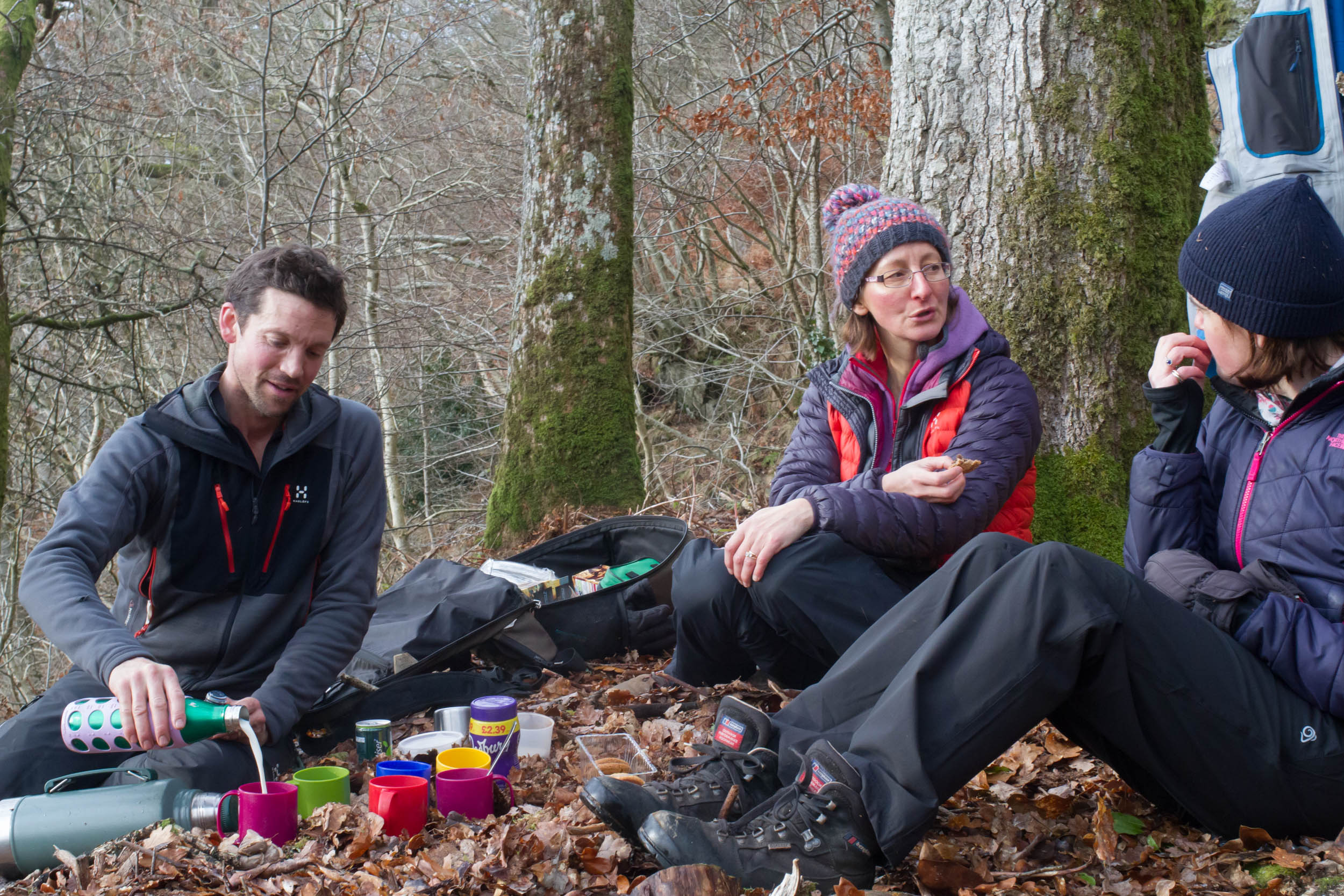 People sitting in the woodlands having hot drinks