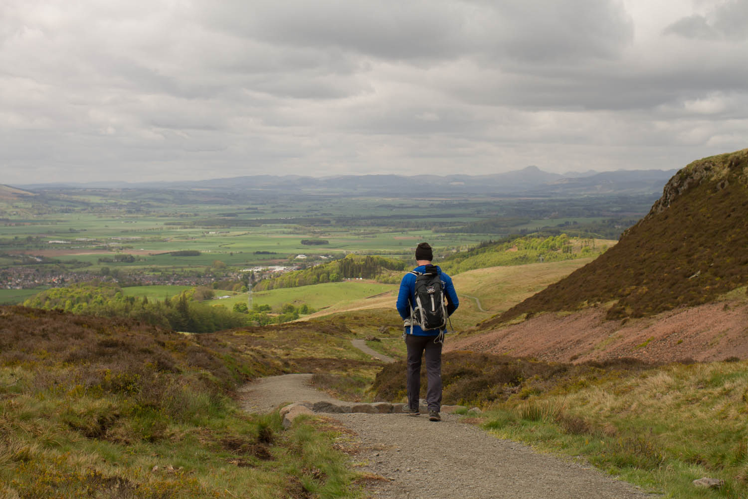 Man walking along trail in the hills in Scotland